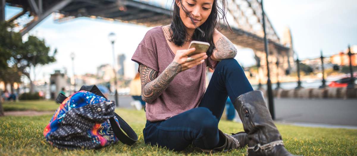 A founder using the Lessly app outdoors under the Sydney Harbour Bridge